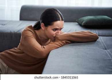 Do not touch me. Negative delighted woman laying with head on the sofa and crying while feeling bad. Depression and bad mood concept