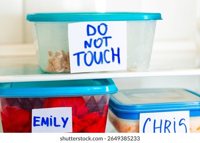 Do Not Touch sticker on lunch boxes in office refrigerator. Angry and hungry workers concept.