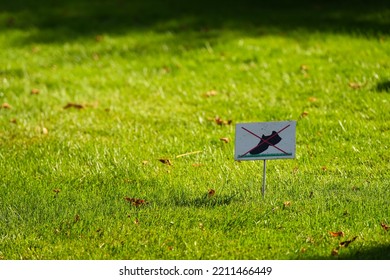 Do Not Walk On The Lawn Grass Sign Placed In A Beautiful Garden.