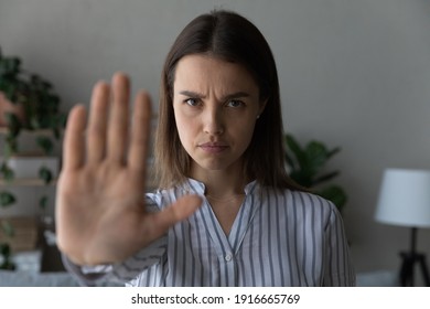 I do not want. Portrait of strong willed millennial woman look at camera raise palm in gesture of prohibition. Young lady saying no stop to discrimination abuse domestic violence. Focus on female face - Powered by Shutterstock