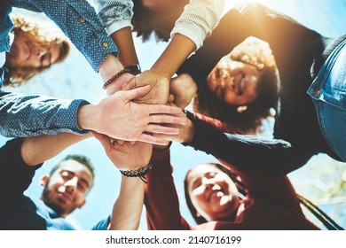 Do it together and do it right. High angle portrait of a diverse group of college friends standing outside with their hands in a huddle.