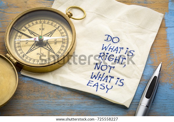 Do what is\
right, not what is easy  advice or reminder - handwriting on a\
napkin with an antique brass\
compass