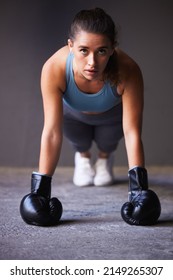 Do You Choose The Pain Of Discipline Or Regret. Portrait Of A Young Woman Exercising While Wearing Boxing Gloves.