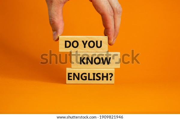 あなたは英語の記号を知っていますか 実業家の手 木の版木に 英語は知ってる と書いてある 美しいオレンジの背景 ビジネス 教育 そして英語のコンセプト コピー用スペースを知っている の写真素材 今すぐ編集