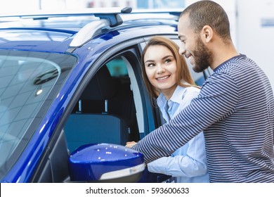 Do You Like It? Beautiful Cheerful Woman Smiling At Her Handsome African American Boyfriend While Choosing A New Car At The Dealership Together Copyspace Couple Love Family International Customers