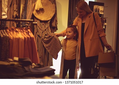 Do you like this? Mother and daughter in the shopping store. - Shutterstock ID 1371051017