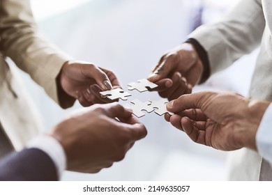 Do you see the bigger picture. Closeup shot of a group of unrecognizable businesspeople joining puzzle pieces together in an office. - Shutterstock ID 2149635057