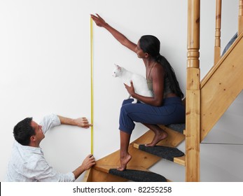 Do it yourself: couple measuring wall to hang picture at home. Horizontal shape, copy space - Powered by Shutterstock