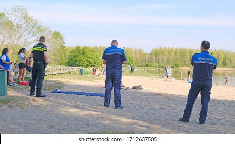 Dobbeplas, Nootdorp, Netherlands. April 23, 2020. Police And Surveillance Officers Working Together To Maintain Social Distancing Rules. Groups Of Youngsters Gathering On The Beach Of Dobbeplas.