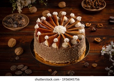 Dobos cake with nuts on dark wooden background