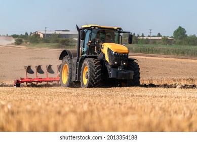 Dobrich, Dobrich region, Bulgaria - 07.02.2019: Modern JCB Fastrac tractor plows agricultural land after harvesting wheat. Preparing the soil for autumn sowing