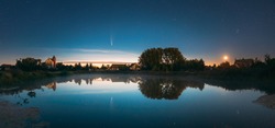Dobrush, Belarus. Comet Neowise C2020f3 Anf Rising Moon In Night Starry Sky Reflected In Small Lake Waters
