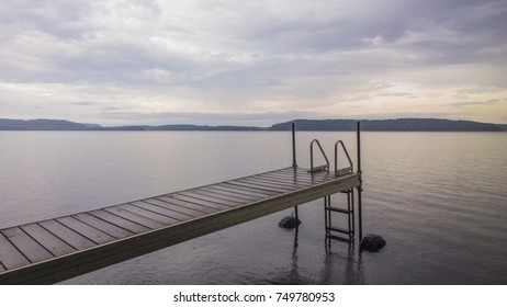 dock with empty ladder going into a lake with mountains