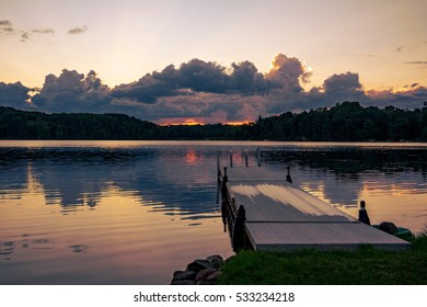 A dock extends out into a lake at sunset on a northern Wisconsin lake.