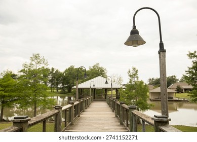 A dock framed by lights extends into the Bayou Maçon in Delhi, Louisiana, USA.