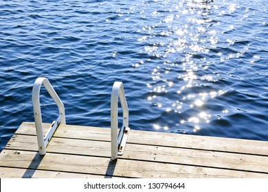Dock and ladder on calm summer lake with sparkling water in Ontario Canada - Powered by Shutterstock