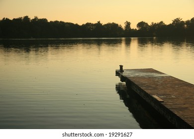 A Dock On A Lake At Sunset