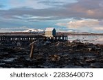 Dock Shack on an Alaskan Beach with Snow and Ice