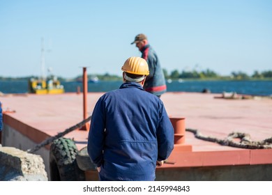 dock workers on a river barge in the port