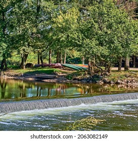 Docked Colorful Canoes And A Waterfall On Neshaminy Creek In Tyler State Park In Bucks County,Pennsylvania USA.