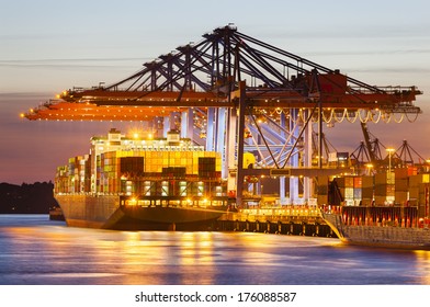 Docked Container Ship In Harbor At Dusk.