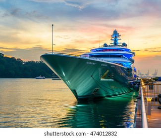 Docked green yacht at sunset in Singapore