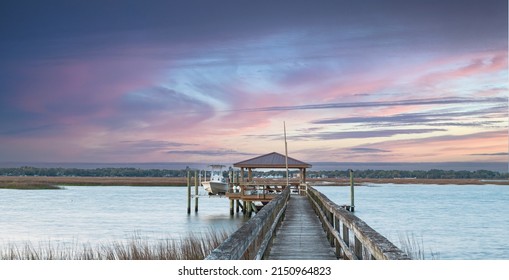Dockside view of boathouse walking on dock with pink sky in Beaufort, South Carolina. - Shutterstock ID 2150964823