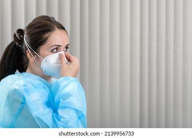 Doctor Adjusting Covid-19 N95 Mask In Admissions Office Before Patient Visits