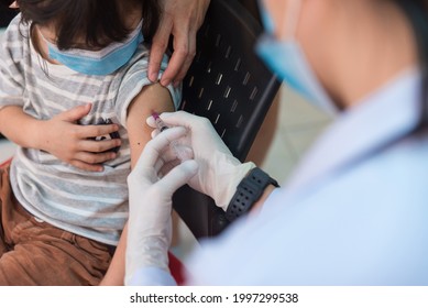 Doctor Administrating COVID-19 Vaccine To A Child Patient At The School. First Safe And Effective Coronavirus Vaccine,