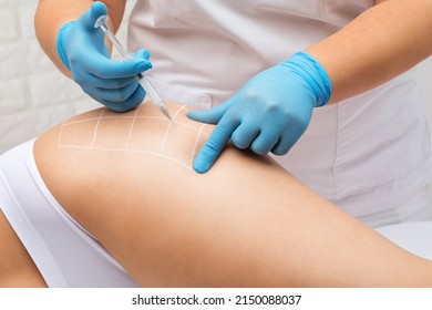 A doctor of aesthetic cosmetology makes lipolytic injections to burn body fat on a woman’s on the hips, legs and thighs . Female aesthetic cosmetology in a beauty salon.