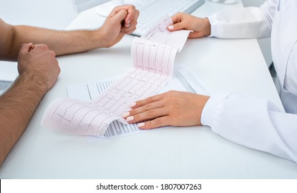 Doctor Analyzes The Electrocardiogram Results, Close-up. Diagnosis Of Arrhythmia, Heart Rate And Heart Disease