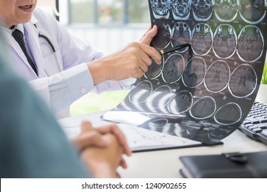 Doctor Analyzing A Scan Or X-ray Film Or Explains A CT Scan Thoughtful Expressions Method Talking To Patient Treatment On Brain To An Anomaly 