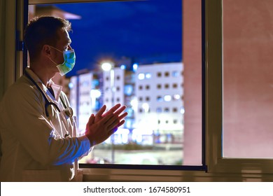 Doctor applauding people who are isolated in their homes because of the coronavirus. This is a solidarity movement started in Spain - Shutterstock ID 1674580951