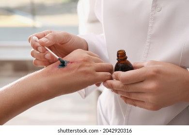 Doctor applying brilliant green onto injured hand indoors, closeup - Shutterstock ID 2042920316