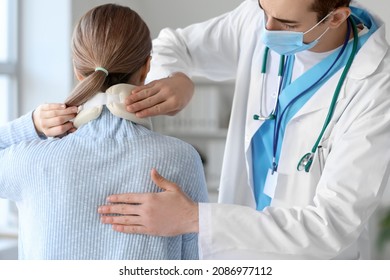 Doctor applying cervical collar on neck of young woman in clinic - Powered by Shutterstock