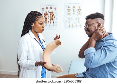 Doctor Applying Cervical Collar On Neck Of African American Man In Clinic. Female Doctor Putting Neck Orthopaedic Collar On Adult Injured Man. Man In Pain At The Doctor For A Neck Injury