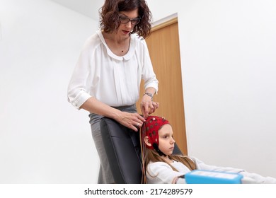 Doctor Applying Electrodes To A Headgear Of A Patient