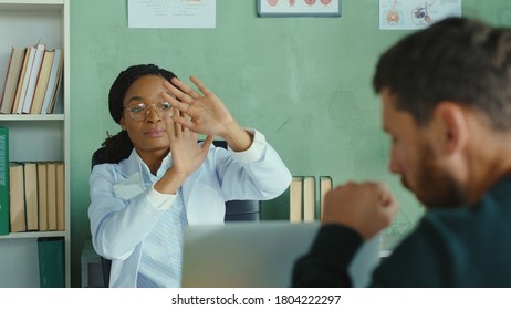 Doctor Appointment. Scared Female Doctor Covering Herself Social Distancing Unhealthy Man Patient Coughing. Hospital Office. Health Care, Pandemic, Virus Infections.