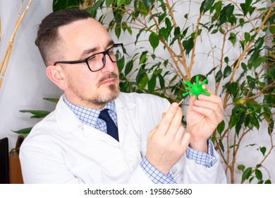 Doctor At Appointment Or Scientist Microbiologist Virologist Shows Model Of Microorganism - Virus Prion Or Bacteria. Demonstration Of Pathogen To Patient - Cause Or Causative Agent Of Disease, Malaise