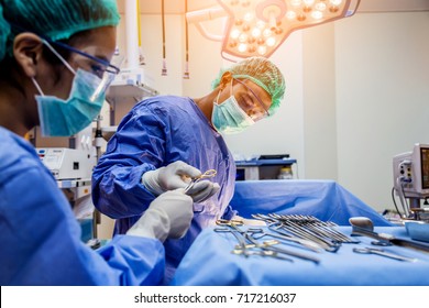 doctor and assistance Medical team performing surgery on a patient with focus and stressful moment in operation room in hospital or clinic health concept - Powered by Shutterstock