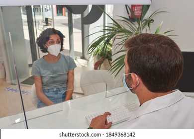 Doctor Attends To His Patient, They Have The Mask On And There Is A Protective Screen. Safety Measures Against Covid-19.