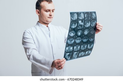 Doctor attentively examines the MRI scan of the patient. At the hospital - Shutterstock ID 670248349
