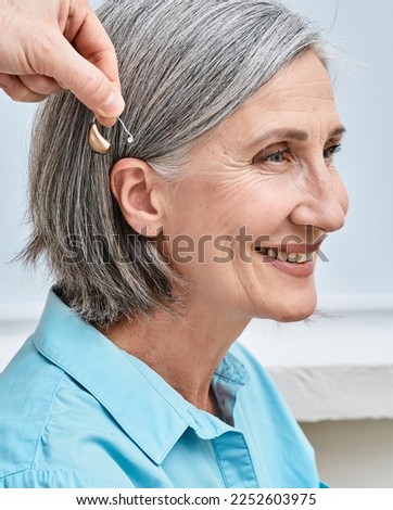 Similar – Image, Stock Photo Woman applying hearing aid to ear