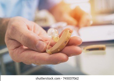 Doctor Audiologist Holding Hearing Aid In His Hand