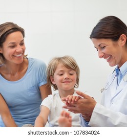 Doctor Auscultating The Forearm Of A Child In Examination Room, Healthcare Workers In The Coronavirus Covid19 Pandemic