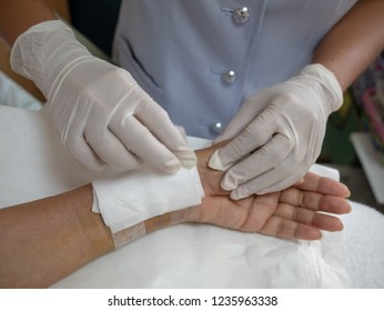 Doctor Is Bandaging Upper Limb Of Patient After Cleaning The Wound From Surgery. Soft Of Focus