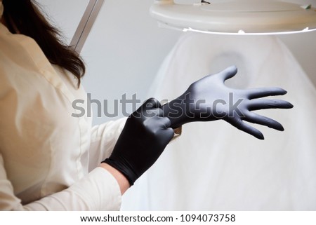 doctor beautician wears sterile black gloves prepares to receive clients