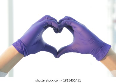 Doctor In Blue Gloves Depicts A Heart With His Hands. Close-up