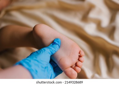 Doctor in blue gloves examines children's feet for the presence of diseases, fungus, flat feet - Shutterstock ID 2149328689