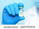 A doctor in blue gloves holding a bottle with vaccine vial of H5N1.Bird flu vaccine. The concept of medicine, healthcare and science.